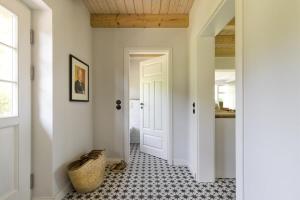 HolzdorfWildhagen 1的走廊设有白色门,铺有瓷砖地板