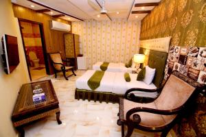 拉合尔Premier Inn Gulberg Lahore的一间卧室,卧室内配有一张床和一把椅子