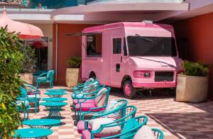 圣安东尼奥湾NYX Hotel Ibiza by Leonardo Hotels-Adults Only的一辆装有桌椅的粉红色食品车