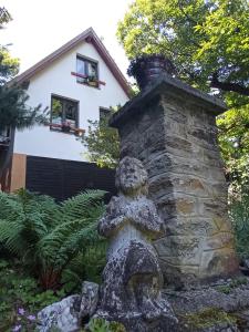韦莱姆Pele vendégház的房屋前有熊雕像的石烟 ⁇ 
