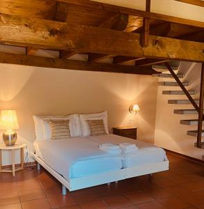 阿斯科纳阿斯科纳广场餐厅酒店 的卧室配有白色的床铺和木制天花板