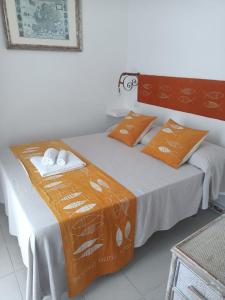 蓬扎Piccolo Hotel Luisa的配有橙色枕头的客房内的两张床