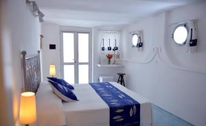 蓬扎Piccolo Hotel Luisa的白色卧室配有蓝色枕头的床