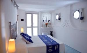 蓬扎Piccolo Hotel Luisa的白色卧室配有一张带蓝色枕头的大床