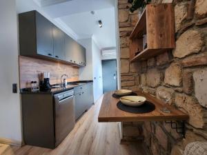 安塔利亚Sera Homes Kaleici Oldtown的厨房配有木桌和石墙