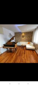 希贝尼克Glorianita sweethome,centro, FREE parking,SELF CHECK- IN的带沙发和钢琴的客厅