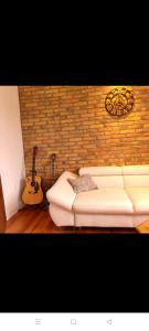 希贝尼克Glorianita sweethome,centro, FREE parking,SELF CHECK- IN的客厅配有白色沙发和吉他
