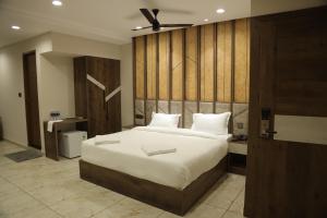 阿鲁法Mezkar Residency的一间卧室配有一张大床和木制床头板