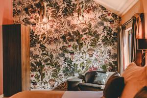 巴尔洛Centraal Baarlo的一间设有花卉壁纸的带沙发的墙壁客房