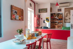 米兰Ostello Bello Milano Duomo的厨房配有桌椅和红色墙壁