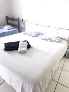 MatozinhosHotel Aconchego Matozinhos的两张带白色床单和毛巾的床