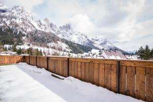 圣马蒂诺-迪卡斯特罗扎Hotel Colfosco的雪覆盖的栅栏,背景是群山