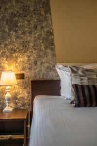 根特奥德伯根酒店的一间卧室配有一张床和一张带台灯的桌子