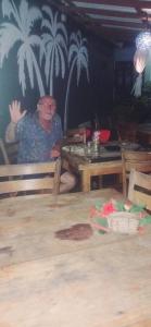 尼甘布Negombo Royal Villa by Hotel Oviniru的坐在餐厅桌子上的男人
