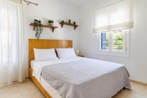 斯科派洛斯Aurora Apartment - Skopelos的白色的卧室设有一张大床和一个窗户