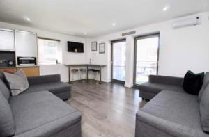 利物浦坎贝尔广场3号公寓的客厅配有两张沙发和一张桌子