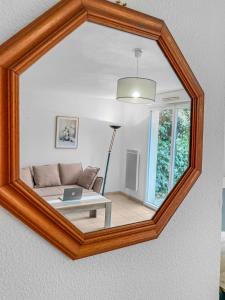 里摩日Périple Authentique à Limoges的镜子反射着客厅,客厅配有沙发和桌子