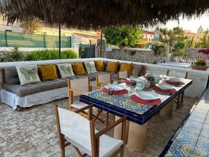 圣克莱蒙Casa Rural Menorquina Con Piscina y Barbacoa的庭院里设有桌椅和沙发。