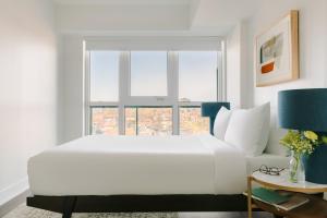 多伦多Sonder at Artesa的白色的卧室设有一张大床和一个窗户