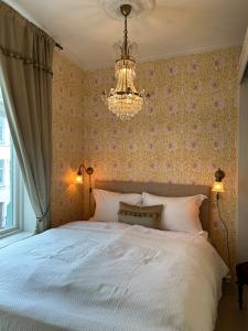 奥勒松Jugend 1903的卧室配有白色的床和吊灯。