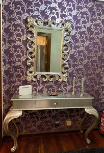 埃拉斯蒂列罗Apartamento El Rincón de Pilar的浴室设有紫色墙壁上的镜子