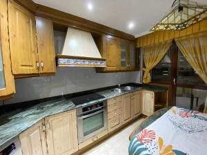 埃拉斯蒂列罗Apartamento El Rincón de Pilar的厨房配有木制橱柜和炉灶烤箱。