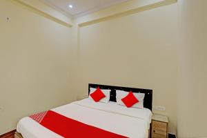 勒克瑙Super OYO Flagship Sunrise Inn的一间卧室配有红色枕头的床