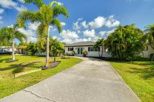 迈尔斯堡Fort Myers Bungalow - 12 Miles to the Beach!的前面有棕榈树的房子