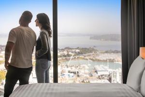 奥克兰voco Auckland City Centre, an IHG Hotel的站在窗前的男人和女人