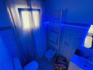Incredibile Appartamento con doccia Idromassaggio的浴室设有卫生间和带蓝光的盥洗盆。