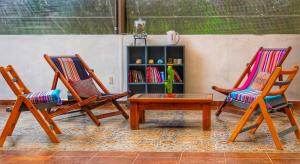 圣克里斯托瓦尔-德拉斯卡萨斯Hotel Ocho Barrios的两张椅子和一张桌子以及书架