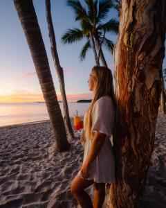 大克佩尔岛大克佩尔岛海德威度假酒店的站在海滩上喝一杯的女人