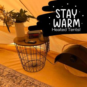 AlonnahBase Glamp Bruny - Heated Tents for 8 People的挂着挂着植物的标牌,上面写着:把暖暖的帐篷放在篮子里