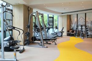 南京南京喜玛拉雅假日酒店的一间健身房,配有跑步机和黄色地毯