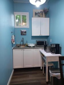 金斯顿Amor Bayridge的厨房配有白色橱柜和蓝色的墙壁