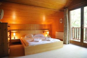 Lachapelle-Auzac苏雅克高尔夫乡村俱乐部公寓酒店的一间卧室配有一张带木墙的大床