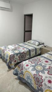 San JacintoHotel Luxury Plaza的两张睡床彼此相邻,位于一个房间里