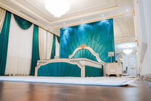 杜尚别KANGURT Grand Hotel的一间设有舞台的房间,里面设有一张床