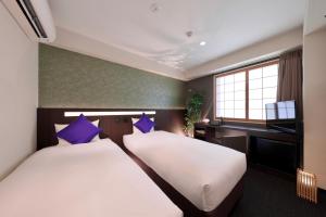 京都丸太町水晶酒店的酒店客房配有两张床和一张书桌