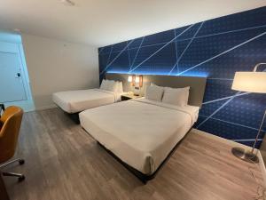 盐湖城Comfort Inn & Suites的酒店客房设有两张床和蓝色的墙壁。