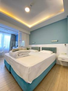凯麦尔Amsterdam Otel & Suite Apart的卧室设有一张大床,拥有蓝色的墙壁