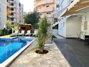 布德瓦Apartments Pribilovic的棕榈树坐在游泳池旁