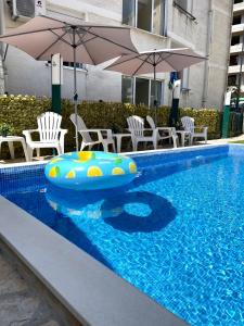 布德瓦Apartments Pribilovic的一个带充气木筏、椅子和遮阳伞的游泳池