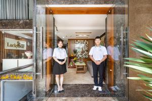 胡志明市Lucky Star Hotel Nguyen Trai Q5的站在门廊上的男人和女人
