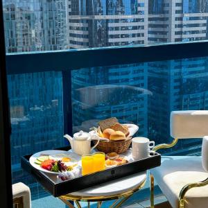 迪拜Emirates Grand Hotel的阳台上桌上的早餐盘