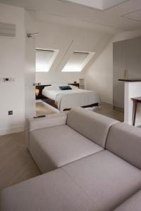 哈罗Luxurious London Studios的一间带两张床和一张沙发的客厅