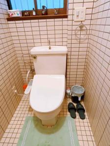 富士吉田市T&T Fujiyama Guest House的一间带卫生间和一双鞋的浴室