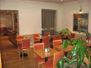 伦敦美洲大酒店的一间设有桌椅的餐厅,以及一间种植了植物的餐厅