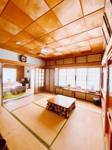 富士吉田市T&T Fujiyama Guest House的大房间设有桌子和床