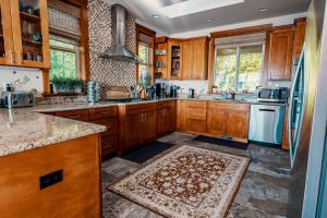 埃德蒙兹Stunning House with Views of Puget Sound! Ideal for Family Reunions的厨房配有木制橱柜和地板上的地毯。